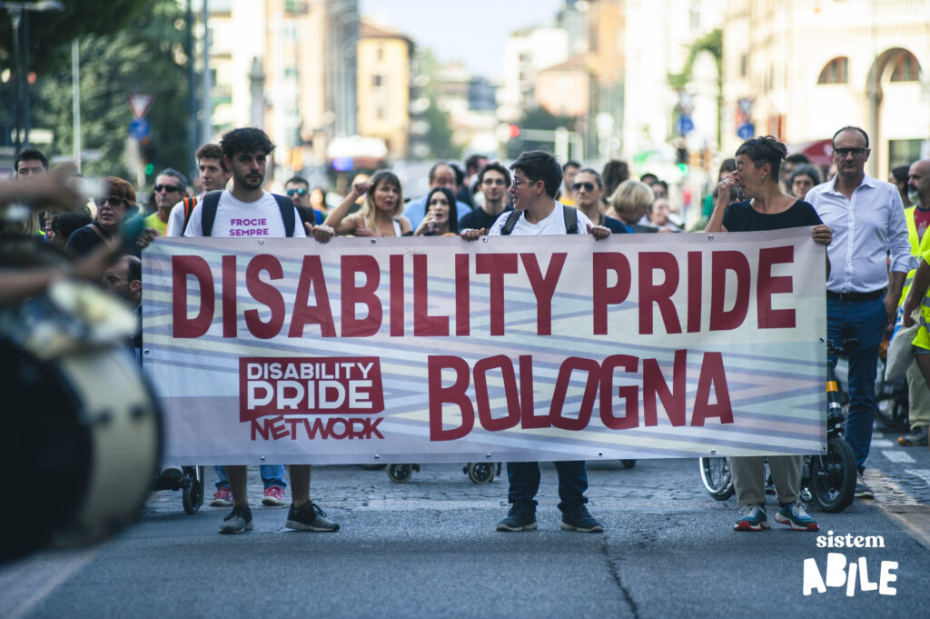 Uno striscione con scritto "Disability Pride Bologna" apre la strada al corteo